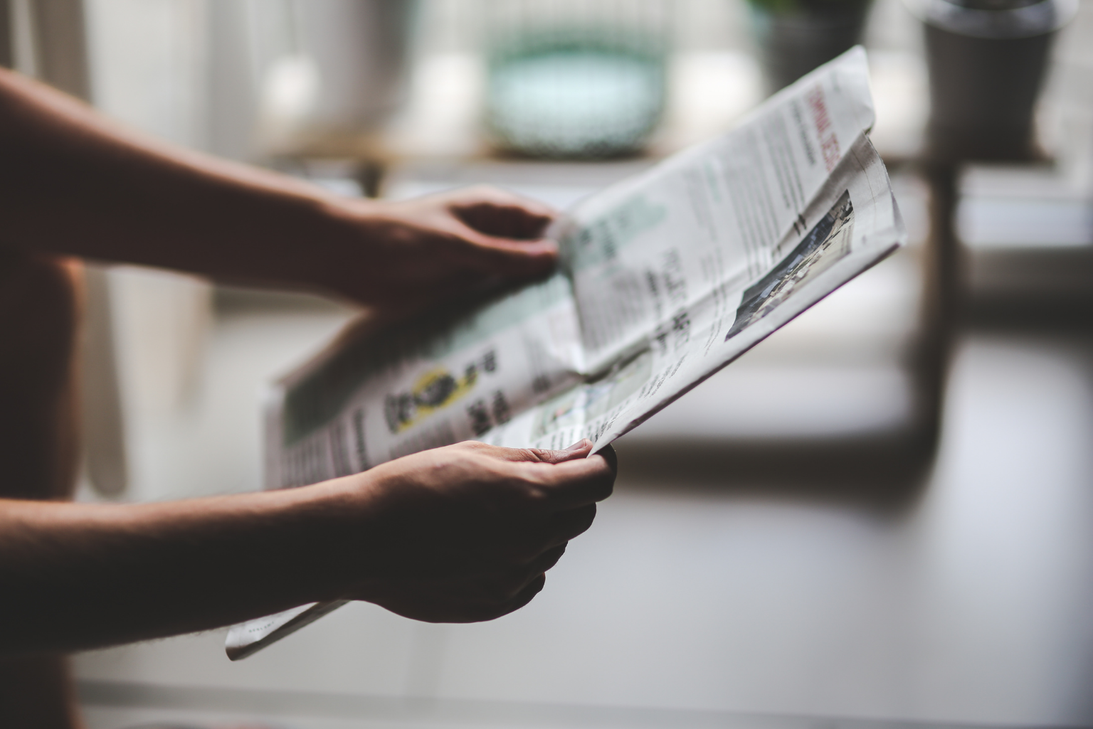 Person, die eine Zeitung in der Hand hält